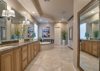 A large bathroom with granite counter tops and a large mirror.