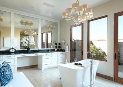 A white bathroom with a bathtub and a chandelier.