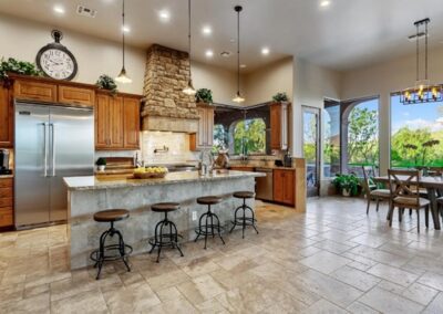 A large kitchen with stone counter tops and stainless steel appliances.