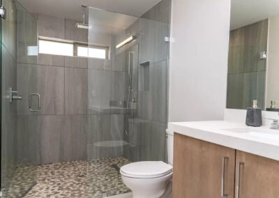 A bathroom with a glass shower stall and toilet.